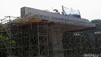 Pekerja merampungkan pembangunan tiang pancang di bawah terik sinar matahari. 