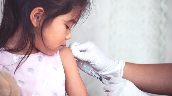 Doctor injecting vaccination in arm of asian little child girl,healthy and medical concept