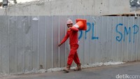 Seorang pekerja melintas di samping proyek flyover Cipinang Lontar.