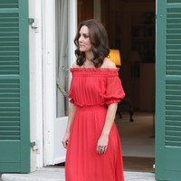 Kate tampil dengan gaya berbeda memakai gaun maxi off the shoulder keluaran rumah mode Alexander McQueen. Gaun merah yang memikat dipadukan bersama sepatu hak tinggi warna nude dari Prada.