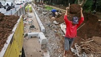 Tanah hasil pengerukan diangkut menggunakan truk.