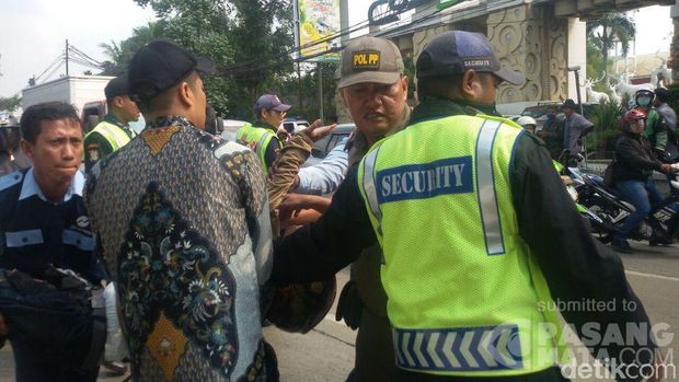 Petugas keamanan dan pengendara motor mengevakuasi pemotor terlindas bus di Daan Mogot