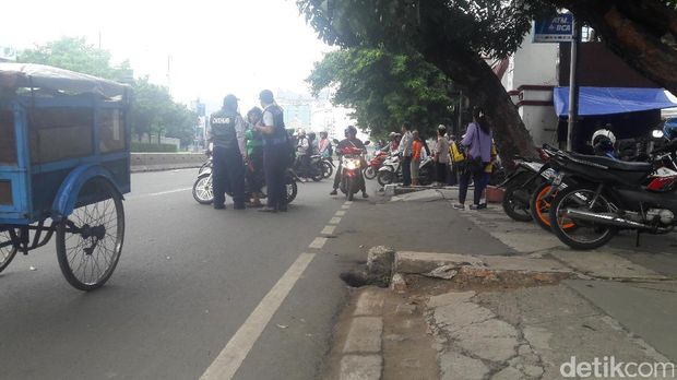 Pemotor bertanya pada petugas dan melakukan putar balik