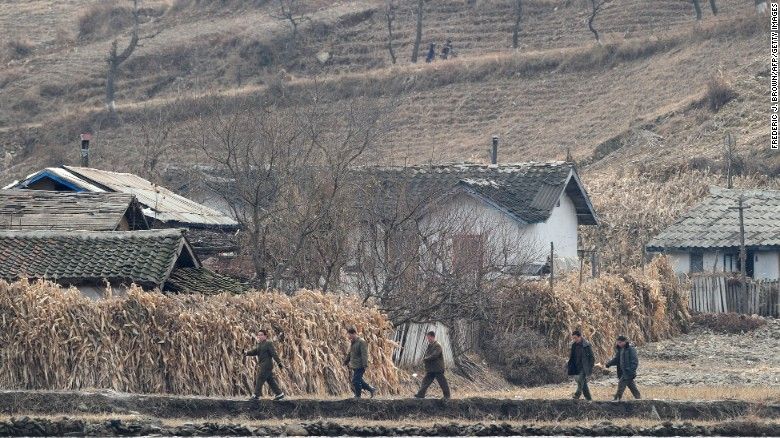 North Korean men walk amid a dry and barren landscape on the banks of the Yalu River in November 2010. (Frederic J Brown/AFP/Getty Images)
