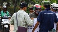 Seorang pemotor berdebat dengan massa yang menghadangnya.