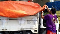 Pekerja memasukkan koper-koper ke atas truk. Menurut salah seorang pegawai, koper-koper tersebut akan dibawa ke gudang di Citeureup karena kantor sudah kelebihan muatan. 