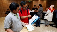 Para jemaah datang dengan membawa berkas.