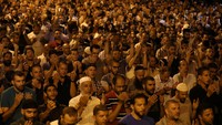 Warga Palestina berdoa bersama di gerbang Lion, Kompleks Kota Tua Jerusalem, Minggu malam (23/7) waktu setempat. REUTERS/Ammar Awad.