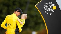 Froome menggendong Kellan dan mengajaknya untuk naik ke podium juara. Foto: REUTERS/Christian Hartmann