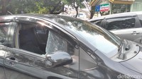 Kaca yang berada di sebelah kemudi itu tak semuanya pecah. Masih ada sisa kaca yang retak menempel di dekat spion.