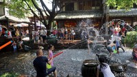 Mereka asyik main air memakai senjata seeperti senapan air. Ada juga yang membawa baskom. Byuur! Mereka asyik saling siram satu sama lainnya (Wahyu/detikTravel)