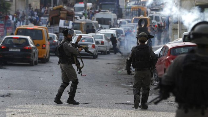 Israeli security forces head towards Palestinian protesters during clashes at the Qalandiya checkpoint, between Ramallah and Jerusalem, in the occupied West Bank, on July 23, 2017, as Palestinians protest against new Israeli security measures implemented at Al-Aqsa mosque complex, known to Jews as the Temple Mount, in Jerusalem.
The new security measures include metal detectors, security cameras, and barring men under 50 from entering the Old City for Friday Muslim prayers, following an attack that killed two Israeli policemen the previous week. / AFP PHOTO / ABBAS MOMANI