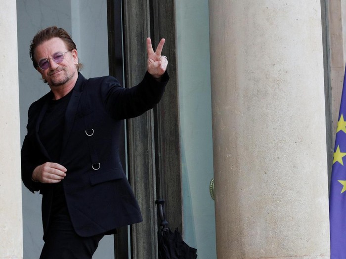 Akrabnya Istri Presiden Prancis dengan Bono U2 Singer Bono of Irish band U2 and co-founder of ONE organization waves as he arrives at the Elysee Palace in Paris, France, July 24, 2017. REUTERS/Philippe Wojazer