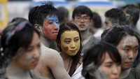 Pasangan turis dalam festival lumpur beberapa tahun lalu pun ada yang memakai lumpur warna-warni di wajahnya (Kim Hong Ji/Reuters)