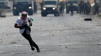 Pemuda Palestina menghindari sasaran tembak polisi Israel. REUTERS/Mohamad Torokman.
