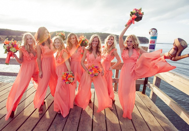 Bosan dengan dress? Kalau begitu, pilih saja seragam bridesmaid dengan model jumpsuit. Jika bisa cari bahan berwarna terang dan hadirkan detail atraktif seperti para briedsmaid ini. (Foto: The Knot)