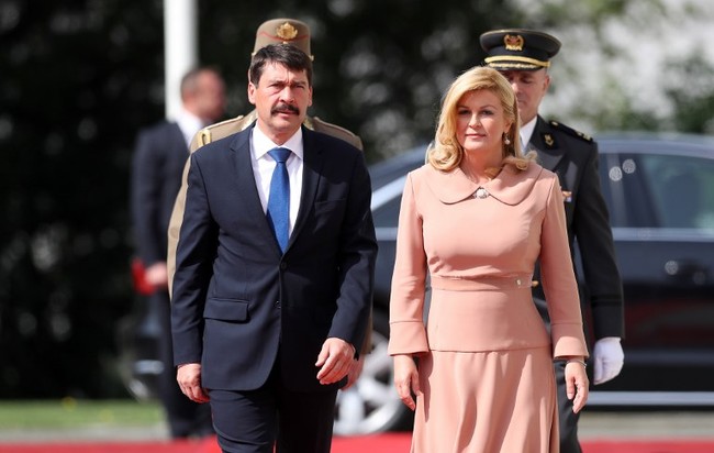 Kolinda Grabar-Kitarovic mengenakan setelan bernuansa pink pastel saat menyambut Presiden Hungaria Janos Ader di Istana Kepresidenan di Zagreb, Kroasia, 12 April 2017. Foto: AFP