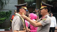 Irjen Pol Idham Azis mengalungkan bunga perpisahan kepada Iriawan.  