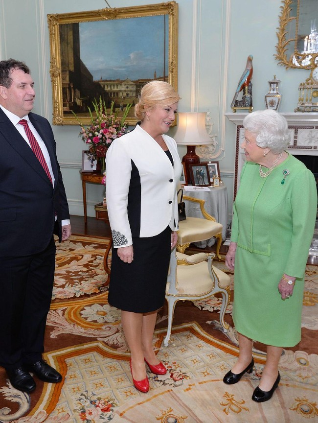Berkunjung ke istana Buckingham dan bertemu Ratu Elizabeth II, Kolinda Grabar-Kitavoric tampil dalam balutan setelan blazer dan rok pensil. Blazer dua warna hitam-putih menampilkan ilusi tubuh presiden Kroasia yang lebih ramping. Foto: Getty Images