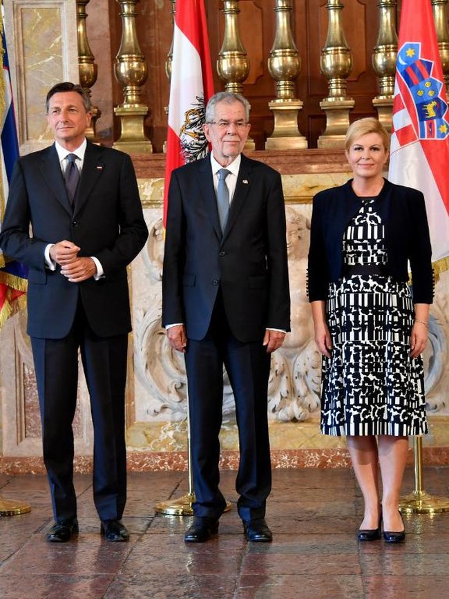 Kali ini busana bernuansa monokrom yang dipilih Kolinda Grabar-Kitavoric saat hadir di konferensi pers bersama Presiden Slovakia Borut Pahor di Salzburg, Austria, 18 Julit 2017. Ia memadukan bolero hitam dan gaun midi bermotif abstrak yang dipadukan pump shoes hitam. Chic dan stylish. Foto: AFP