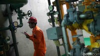 Seorang petugas mencatat hasil pengecekan pipa PLTA.