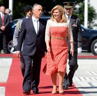 Kolinda Grabar-Kitavoric tampil feminin berbalut gaun midi dengan sentuhan lace atau brokat warna coral-putih saat menyambut Presiden Portugal Marcelo Rebelo de Sousa di Zagreb, Kroasia, 18 Mei 2017. Foto: AFP