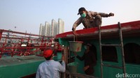 Nelayan melakukan perbaikan kapal saat bersandar di Pelabuhan Muara Angke, Jakarta, Selasa (25/7/2017).
