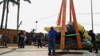 Proses pemasangan patung menggunakan alat berat crane.