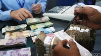 Warga menghitung uang yang telah rusak untuk ditukarkan di Bank Indonesia.