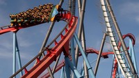 Pengunjung berpetualang dengan roller coaster Dragon Khan berwarna merah di PortAventura resort, Barcelona, 25 Juli lalu. REUTERS/Albert Gea.