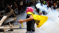 Seorang demonstran melemparkan bom molotov. REUTERS/Carlos Garcia Rawlins.