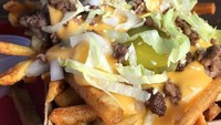 Stik kentang goreng ini diberi topping yang makanan gurih dan juga sayur. Lelehan saus keju dengan cincangan daging sapi semakin cocok dipadukan dengan pickel timun dan juga irisan selada renyah. Tak lupa taburan wijen juga ditaruh di atasnya. (Foto: Istimewa)