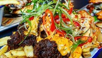 Aduh, lelehan keju berwarna kuning disandingkan dengan bumbu berwarna cokelat dan irisan cabai enak juga dijadikan sajian poutine. Penasaran? (Foto: Istimewa)