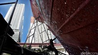 Pekerja memoles lambung kapal sebelum diberi serat fiber dan cairan anti bocor.