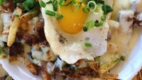 Kentang goreng yang satu ini diberi dengan balutan saus creamy. Terlihat saus yang berwarna putih dengan campuran telur mata sapi dengan irisan daun bawang. (Foto: Istimewa)