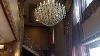 Di sisi kanan berjajar kursi berbahan beludru berwarna ungu. Kemudian lampu-lampu kristal dan vas bunga menghiasi ruangan ini.