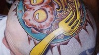 Ini bisa dibilang tato makanan paling ekstrem. Gambar telur sampai garpu dibuat di kepalanya. Ada-ada saja!