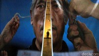 Seorang pengunjung melihat foto-foto yang dipamerkan.