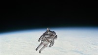 Seorang astronot beraktifitas dengan latar belakang planet bumi. (Foto: NASA)  