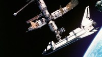 Pesawat Atlantis mengisi bahan bakar dari stasiun luar angkasa Rusia, Mir, (4/7/1995). Bi bagian kanan bawah, terlihat sebagian bumi yang bulat. (Foto: NASA)