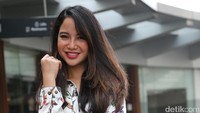 Ia memadukan gaya busananya tersebut dengan tas tenteng berwarna merah. (Foto: Hanif Hawari/detikHOT)
