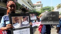 Para karyawan TransJakarta membentangkan poster-poster di depan kantor Komnas HAM.