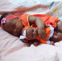 Bayi lucu berbaju kembar dengan boneka. Foto: Istimewa