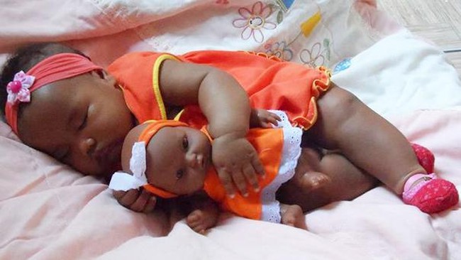 Bayi lucu berbaju kembar dengan boneka. Foto: Istimewa