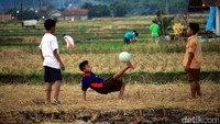 Beberapa anak bermain sepakbola di persawahan di Kampung Sukasari, Desa Mekarpawitan, Kecamatan Paseh, Kabupaten Bandung, Jawa Barat, Minggu (29/7/2017).
