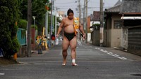Pesumo bernama Kainishiki sedang berjalan pulang seusai menjalani latihan di Kuil Ganjoji Yakushido. Meski bukan asli Jepang, para pesumo ini tetap menghormati kebudayaan asli Jepang (Issei Kato/Reuters)