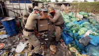 Sejumlah personel Satpol PP membantu memindahkan barang-barang milik warga di Taman BMW, Selasa (1/8/2017).