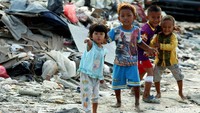 Beberapa anak bermain di sekitar tumpukan sampah di Taman BMW.