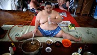 Salah satu pesumo bernama Kaiho ini sedang menikmati santap siang setelah selesai menjalani sesi latihan pada pukul 10.30 pagi. Dalam sehari, para pesumo biasanya makan besar sebanyak 2 kali (Issei Kato/Reuters)