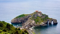 Foto: Gaztelugatxe dengan daratan utama memang terhubungan jembatan buatan yang berliku tersebut. Jembatan ini dibangun dengan semenanjung kecil yang berbatu di kanan kirinya (Thinkstock)